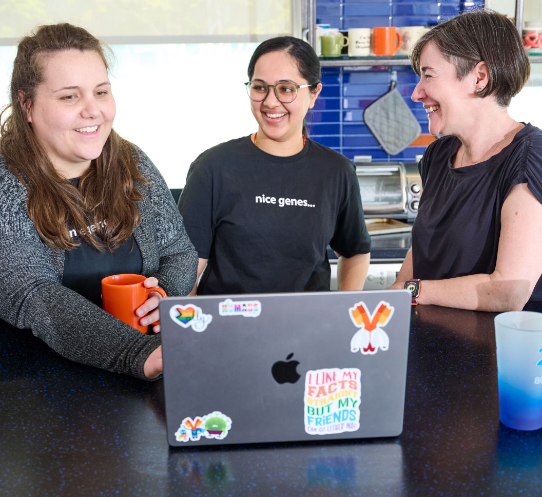 A group of women smiling at a computer
